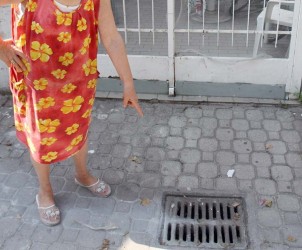 SAL -  tombino tombini degrado via ligea nella foto una signora del posto mostra il tombino davanti alla sua abitazione dal quale fuoriescono odori insostenibili